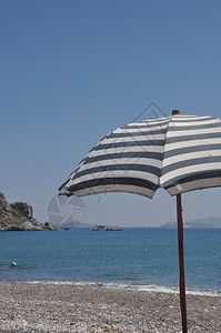 清除海滨白色的希腊Kefalos海滩高斯带希腊雨伞的美丽海滩场景图片