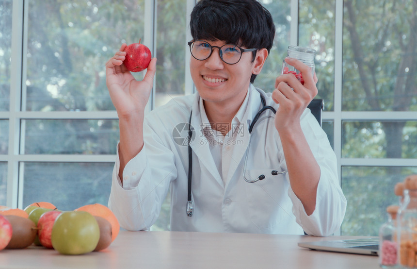 听诊器损失医生或营养学家持有苹果和维他命瓶子在诊所良好的健康始于你有用的食物概念或者图片