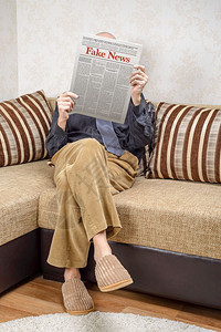 费雷登沙尔房间衬衫一名戴眼镜的男人坐在家里沙发上看报纸导假新闻冒消息LoremImpsum文本大报背景