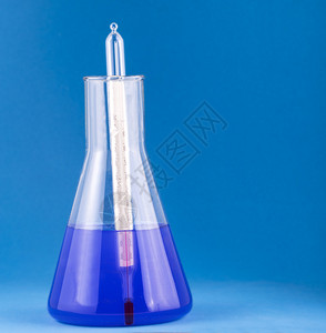 具有复制空间的蓝色背景带温度计的实验室玻璃瓶降低研究医疗的图片