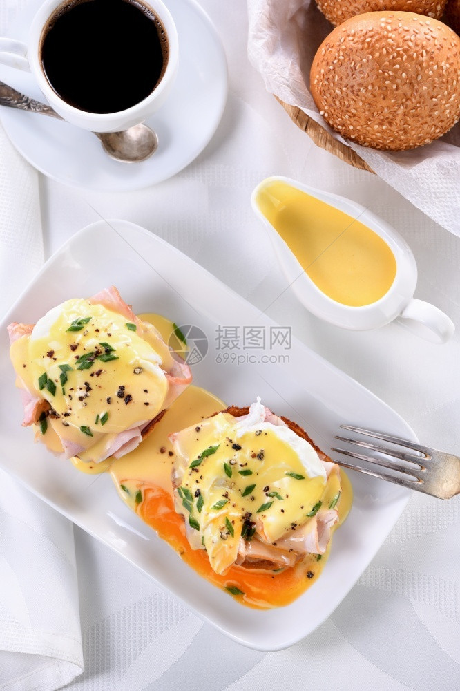 荷兰语黄油菜肴在一条肉汁船上的荷兰奶油酱早餐配鸡蛋本尼迪克特炸英国面包火腿偷吃鸡蛋一杯咖啡图片