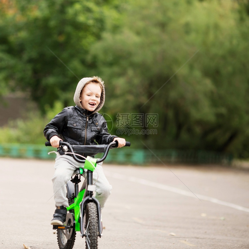 落下街道穿着黑色皮夹克的可爱小城市男孩肖像风格孩子这男学会骑自行车孩子驾驶自行车孩子驾驶脚踏车舵手图片