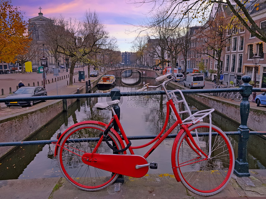 荷兰语古董吸引力日落时在荷兰阿姆斯特丹运河骑车图片