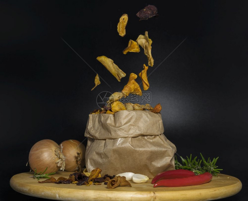 由蔬菜或薯片制成的健康芯在木桌上用洋葱大蒜红胡椒和菜粉放在纸袋中热的油炸木制图片