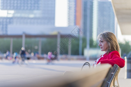 商业人类女孩金发放松的商人坐在城里的长椅上图片