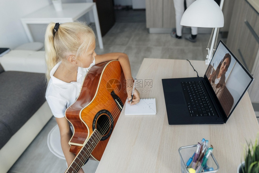 年轻的流行音乐女孩学习如何弹吉他白色的图片