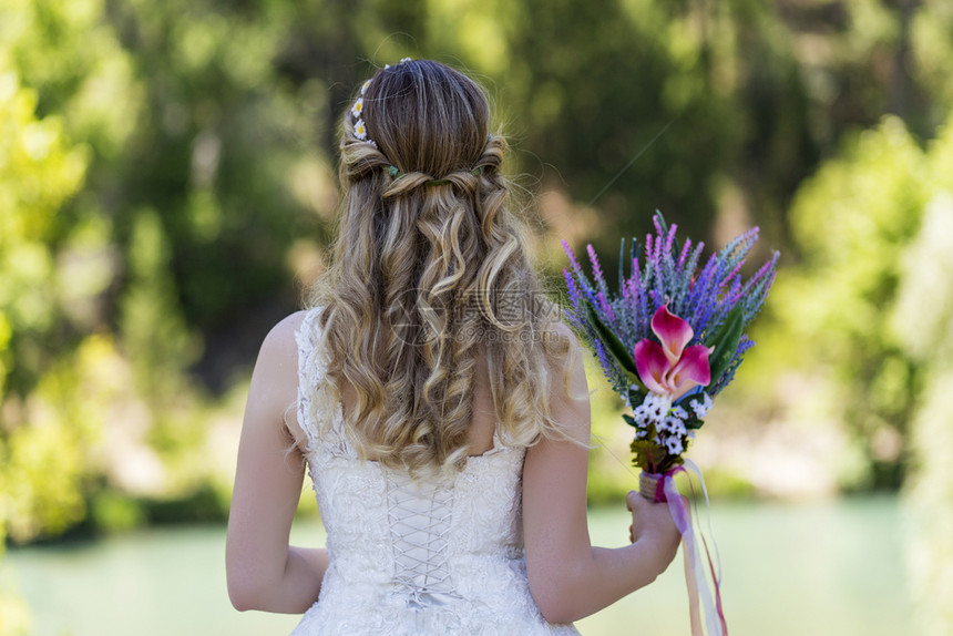 新娘站在海边手里的鲜花在她上幸福波西米亚风格花束图片
