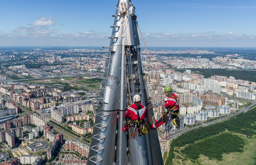 高处的工人安装员在摩天大楼的顶部工作高处的人安装员在摩天大楼的顶部工作较高知名度清洁器拉赫塔图片