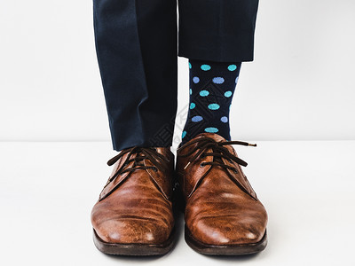 xo型腿办公室经理人穿着时装蓝裤子和光亮多彩的袜子穿着白色孤立的背景摄影室合片生活方式概念娱乐和优雅型鞋办公室经理人风趣和优雅型鞋闪亮袜背景