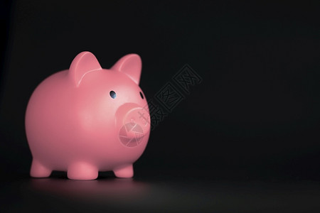 发光小猪粉色的节省简单黑色背景上水平的粉色小猪银行带有复制空间商业储蓄和金融概念阴影黑色背景上水平的粉色小猪银行带有复制空间储蓄和金融概设计图片