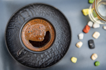 一种黑色的传统土制咖啡现代黑杯中含水和糖的土耳其传统咖啡老的图片