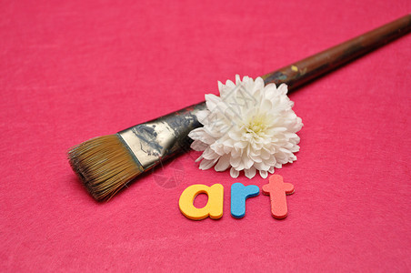 粉红色背景的画笔和白色绿箭侠上面写着艺术这个词鬃翠菊单背景