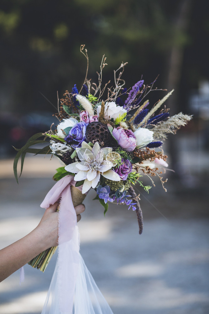 嬉皮士波西米亚风格新娘和手上的鲜花庆典图片