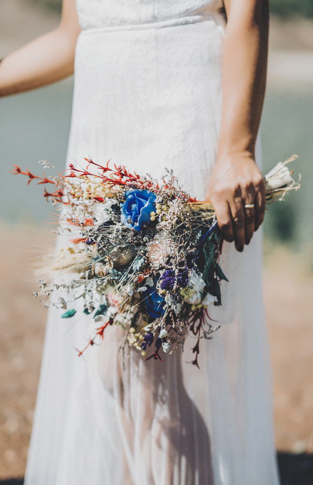 可爱的场地波西米亚风格新娘和手上的鲜花图片