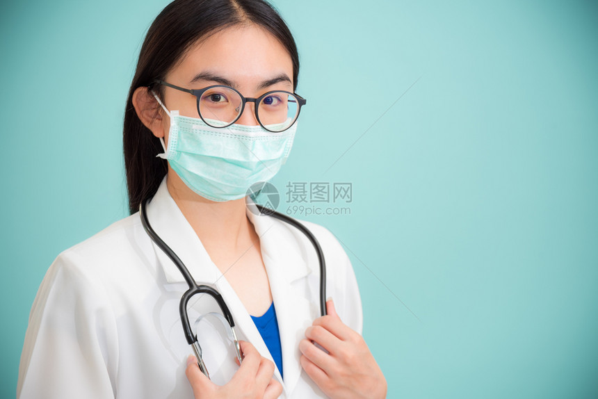 专业的摄影演播室肖像片美丽的亚洲年轻女青医生穿白制服的听诊器医生戴眼镜和绿面罩以保护科罗纳健康保护科罗纳在绿色空间背景上观看摄像图片