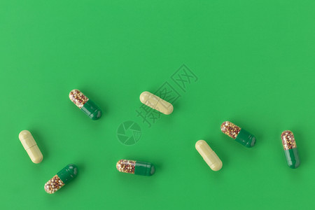 绿色背景上的各种胶囊药物图片