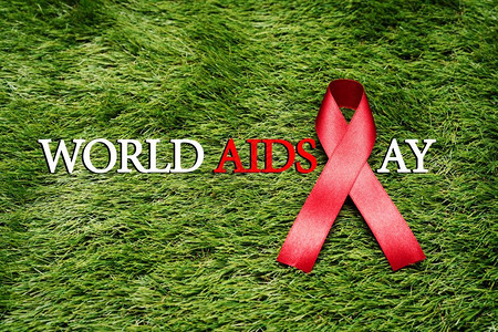 预防出生缺陷庆典抗艾滋在绿草上的标志AIDS意识信号红丝带免疫缺陷幸存者设计图片