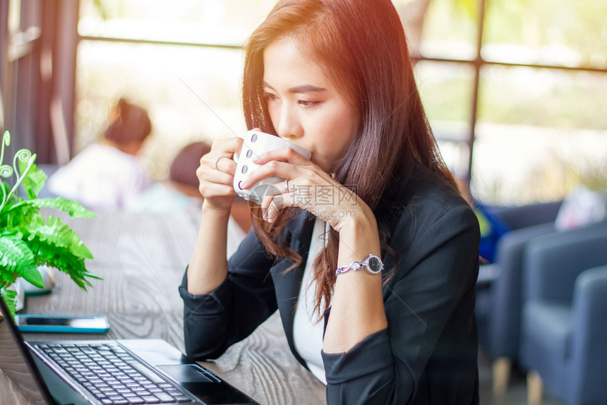成人亚洲女商在咖啡店工作休息时间在咖啡店喝沟通现代的图片