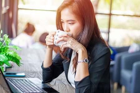 成人亚洲女商在咖啡店工作休息时间在咖啡店喝沟通现代的图片