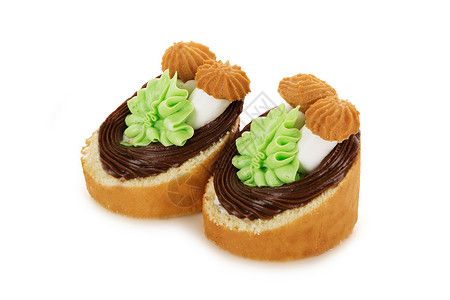 美味的以鲜奶油花和白色背景隔离的蘑菇为装饰饼干蛋糕黑暗牛奶图片