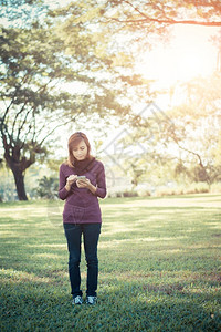 人们对话独自一在公园写智能手机文字中站立的妇女外部图片