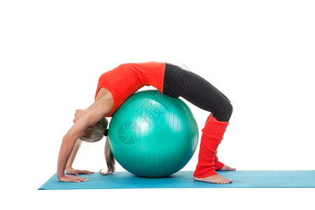练习正在做一名妇女全身被射中在垫子上用圆球操练橙色绿和黑颜水平的图片