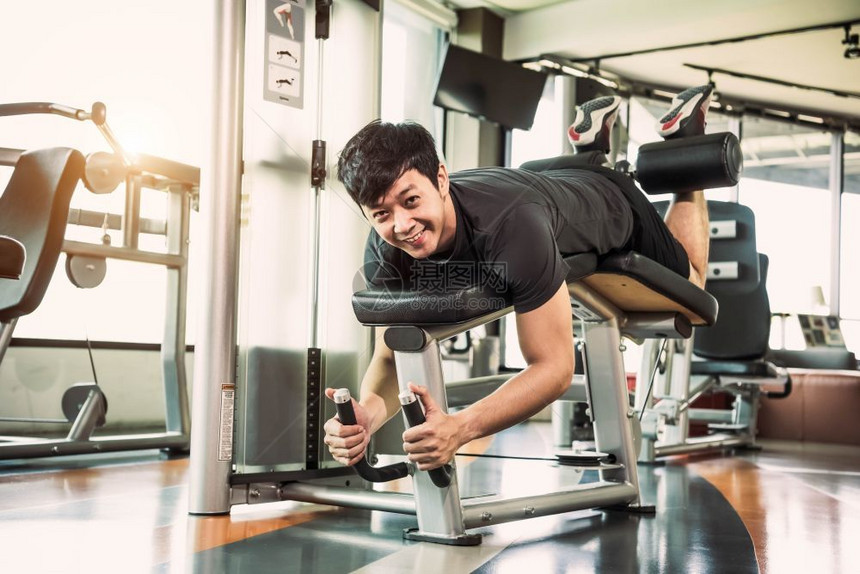 在室内亚洲运动员在体育馆以共居背景的体育和人生活方式概念面对健身房伸展肌肉时举起两条腿拉伸和抬举重量人们运动型图片