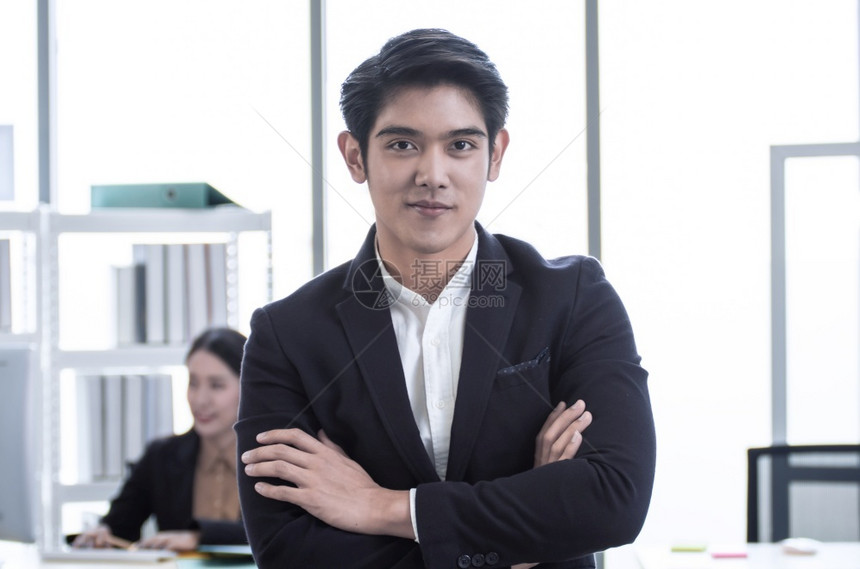 一个年轻的亚洲英俊商人肖像站在办公室满怀自信地微笑着容衣领公司的成人图片