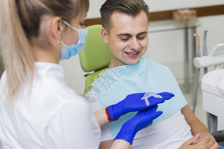 正畸显示隐形保留员的牙医病人保持在职的图片