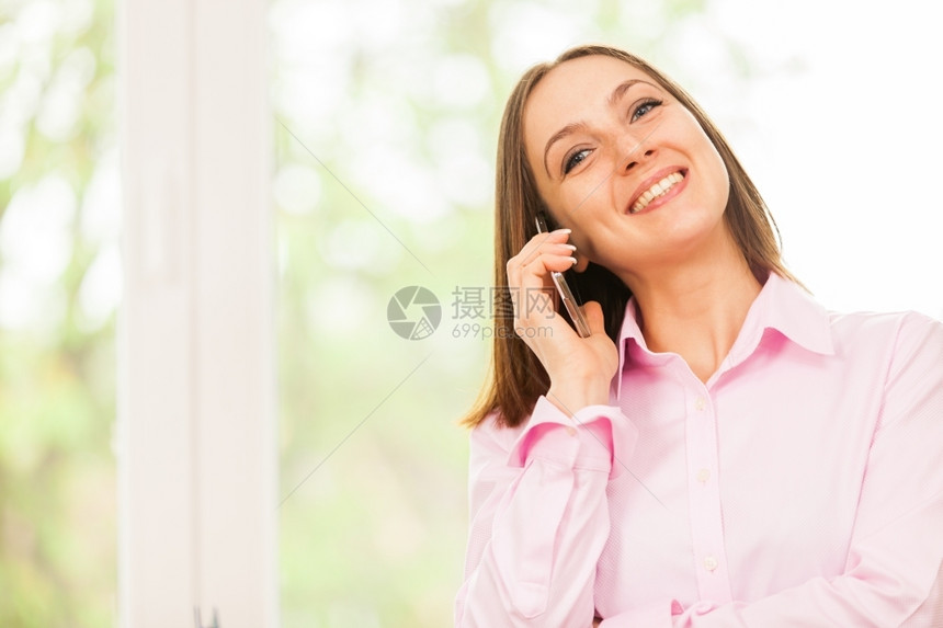 老板公司的女士白种人笑着的女商正在打个电话图片
