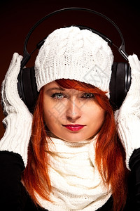 派对声音红发女人与冬季装扮的照片用耳机收听音乐脸图片