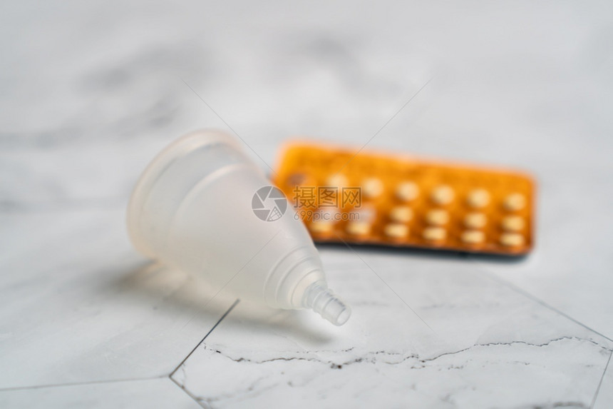 可重复使用的别卫生避孕药丸和白大理石底的月经杯图片
