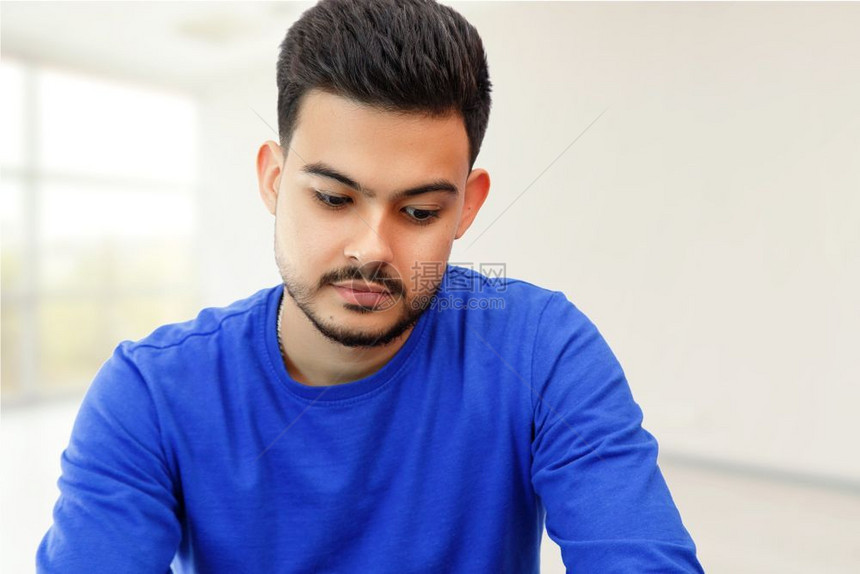 一种男在个年轻人坐笔记本电脑上寻找工作在互联网上从事轻背景商业活动学生图片