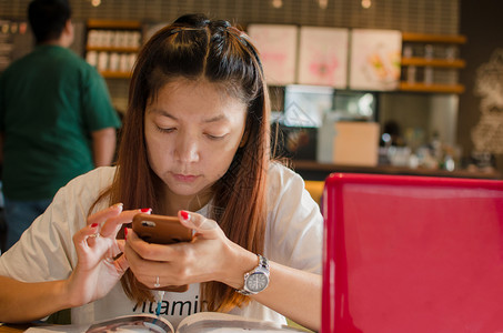 亚裔女孩坐在咖啡厅的店里工作博主屏幕人们背景图片