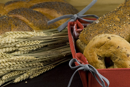 不同种类的新鲜烤面包篮子中各式样晚餐温暖的木制图片