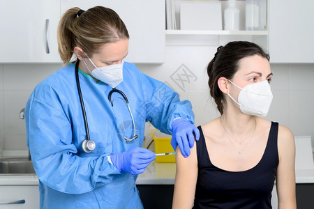 戴口罩的女性接种疫苗图片