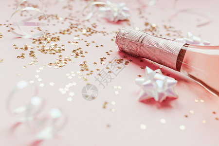 快乐的灯圣诞或新年配有玫瑰香槟和金光闪的星彩蛋白在粉色面背景上边观党庆祝会创意概念的歌唱会粉色背景图片