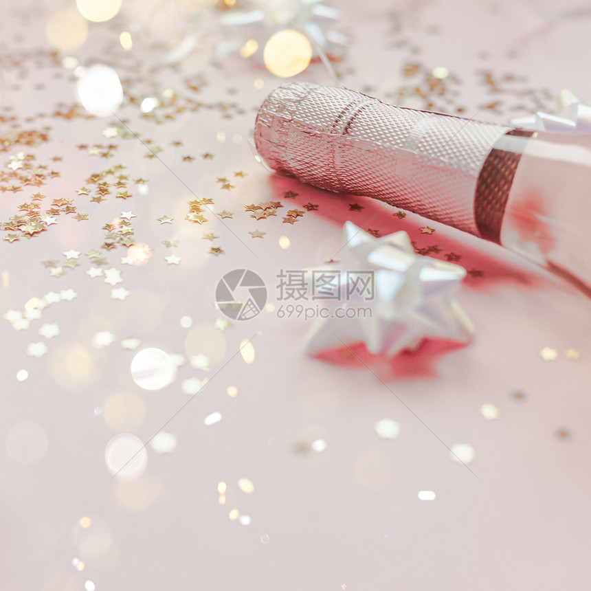 瓶子或者圣诞新年配有玫瑰香槟和金光闪的星彩蛋白在粉色面背景上边观党庆祝会创意概念的歌唱会气泡图片