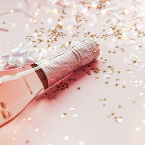 周年纪念日圣诞或新年配有玫瑰香槟和金光闪的星彩蛋白在粉色面背景上边观党庆祝会创意概念的歌唱会圣诞节闪发光背景图片