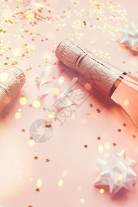 火花葡萄酒圣诞或新年配有玫瑰香槟和金光闪的星彩蛋白在粉色面背景上边观党庆祝会创意概念的歌唱会聚背景图片