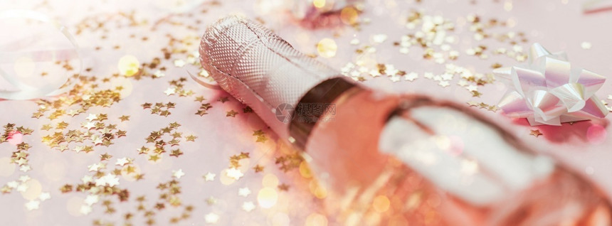 有创造力的乐趣圣诞或新年配有玫瑰香槟和金光闪的星彩蛋白在粉色面背景上边观党庆祝会创意概念的歌唱会喝图片