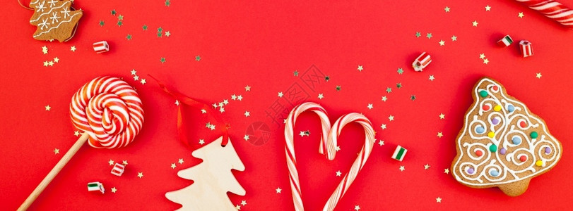 糖果铺新年或圣诞装饰公寓铺着最顶端的视野Xmas节庆祝手工制作装饰木玩具甜金星在红纸背景上闪亮相发光的宽甘蔗背景