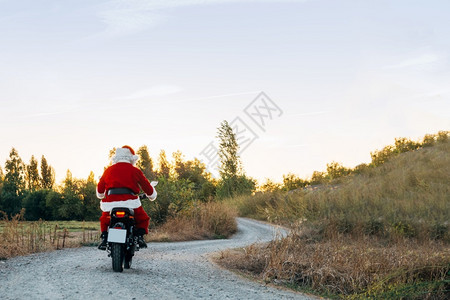 圣诞老人在路上骑摩托车圣诞老人在路上骑摩托车套装驾驶粗糙的图片