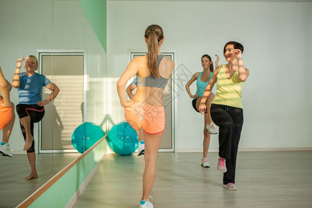 少数妇女群体在健身工作室做有氧锻炼活动力专注人们高清图片