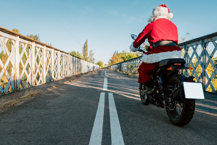 SantaClaus在路上骑摩托车圣诞节的时候司机一种图片