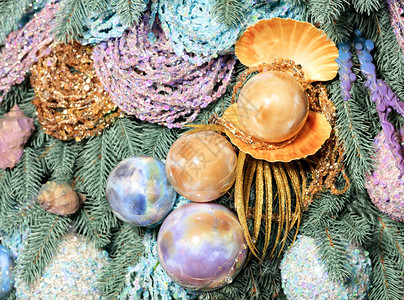 海洋风格的圣诞装饰品特写玻璃圣诞小玩意海形状的大珍珠球金色粉和蓝的调挂在圣诞树的装饰枝上金色粉和蓝的大珍珠球挂在圣诞树的装饰枝上背景图片