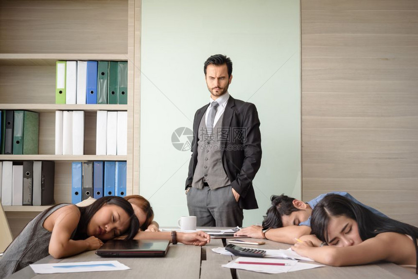 沮丧白种人商看着员工睡在办公室会议的员工们每天晚上10点5分图片