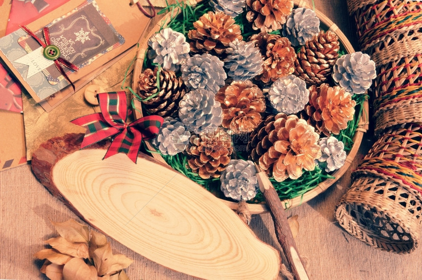 与天然材料的压抑安排艺术篮子中的圣诞松锥向奥华板发送信息的木笔用于装饰的Xmas纸牌古董风格为了惊人的好图片
