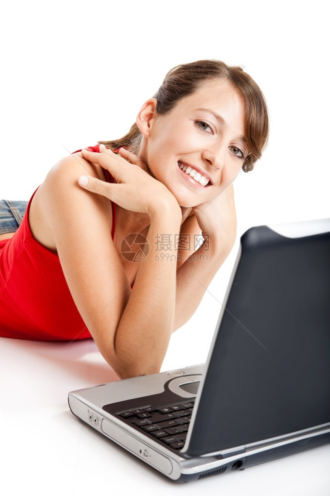 坐在地板上工作着笔记本电脑的美丽和快乐年轻女子吸引人的年轻可爱图片