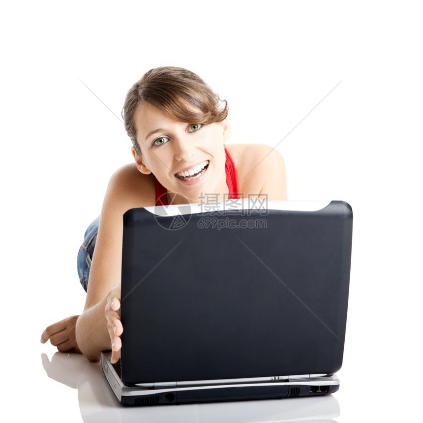 微笑技术无线的坐在地板上工作着笔记本电脑的美丽和快乐年轻女子图片
